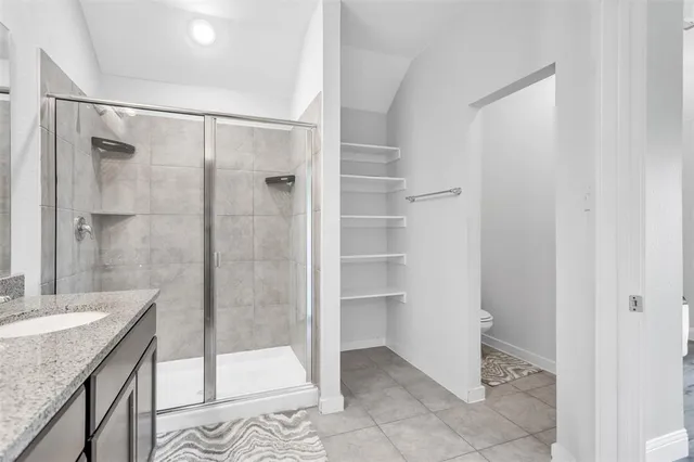 a bathroom with a granite countertop sink a mirror a glass door a shower and vanity