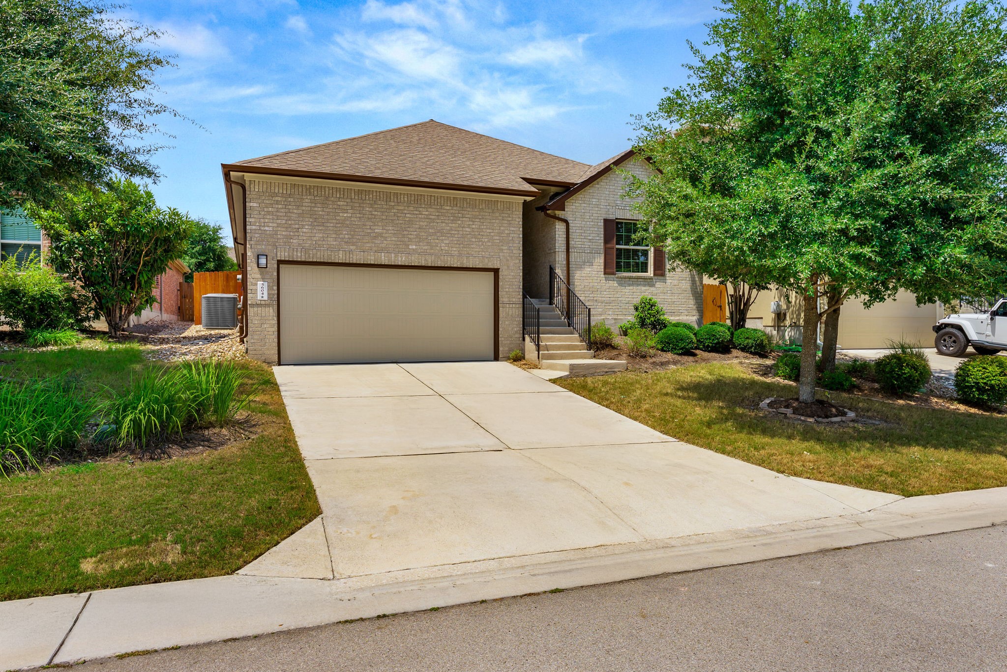 5604 Rio Chama Cove Austin, TX 78738 - Photo 1 of 1 View of front of house featuring brick siding, concrete driveway, a shingled roof, and an attached garage