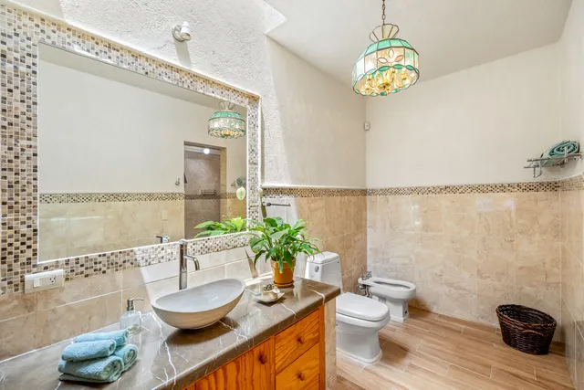 a bathroom with a granite countertop sink a toilet and a mirror