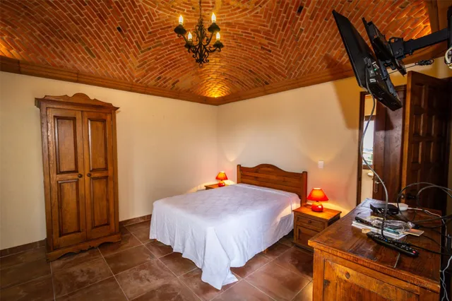 a bedroom with a bed and a flat tv screen on the wall