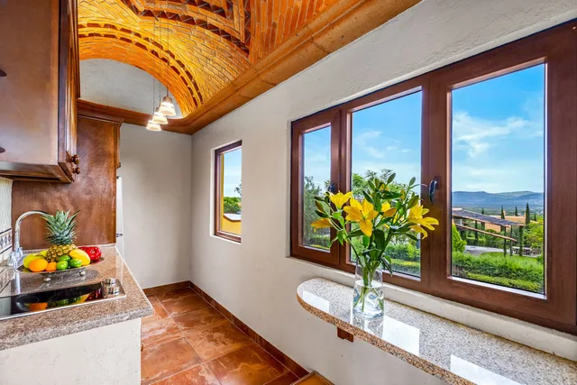 a dining room filled with furniture and a potted plant