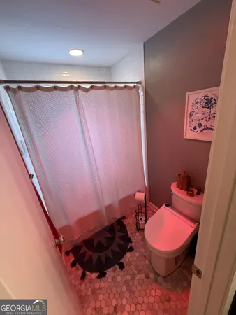 a bathroom with a granite countertop toilet sink and mirror