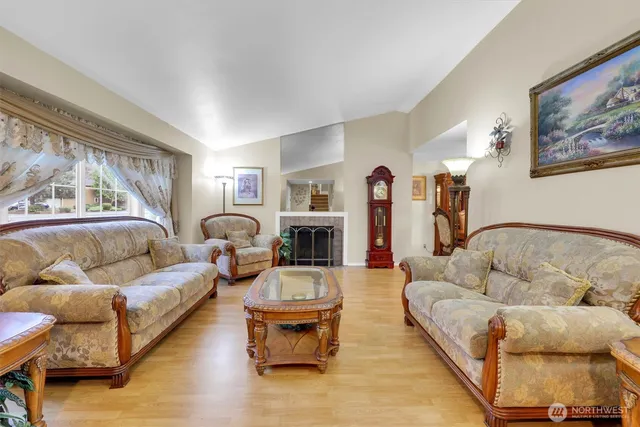 a living room with furniture fireplace and a large window
