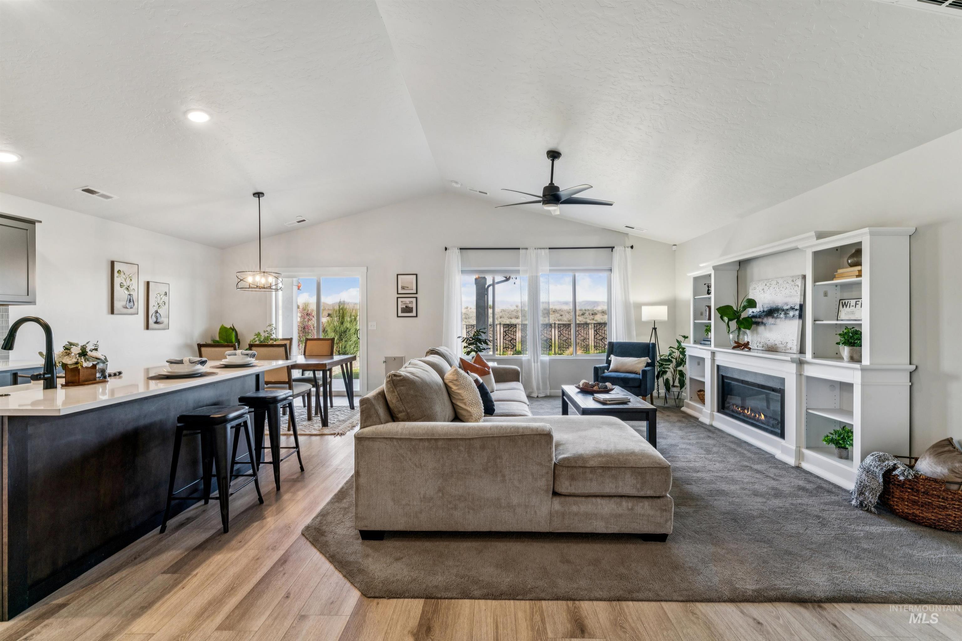 8386 South Bogus Rdg Avenue Boise, ID 83716 - Photo 14 of 50 Living room with ceiling fan, light wood-style floors, and a glass covered fireplace