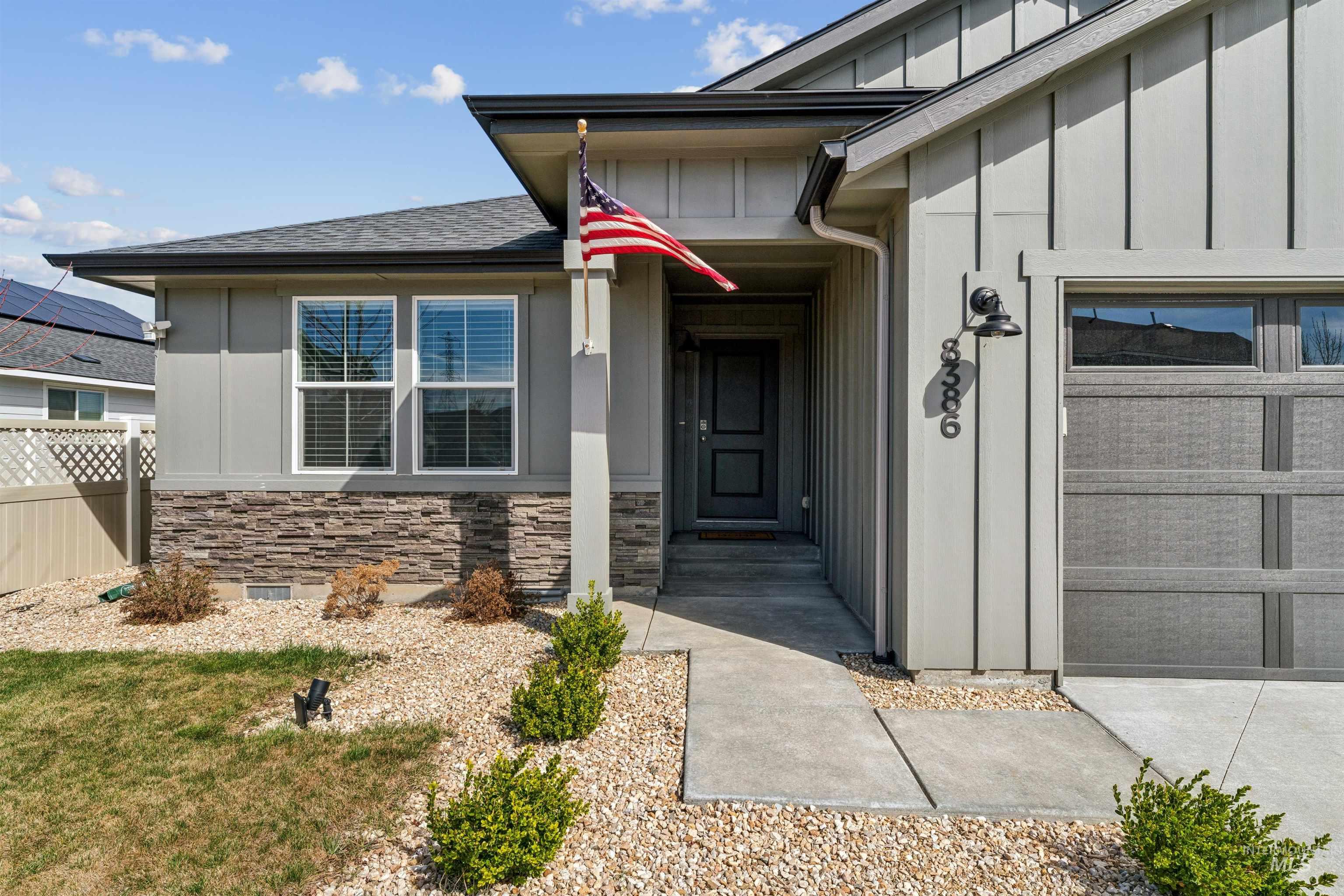 8386 South Bogus Rdg Avenue Boise, ID 83716 - Photo 2 of 50 View of exterior entry featuring board and batten siding, an attached garage, stone siding, and a shingled roof