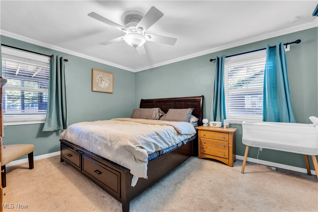 7479 Macedonia Road Bedford, OH 44146 - Photo 28 of 42 Bedroom with multiple windows, light colored carpet, ornamental molding, and ceiling fan