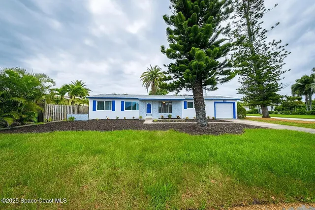 a front view of a house with patio and garden
