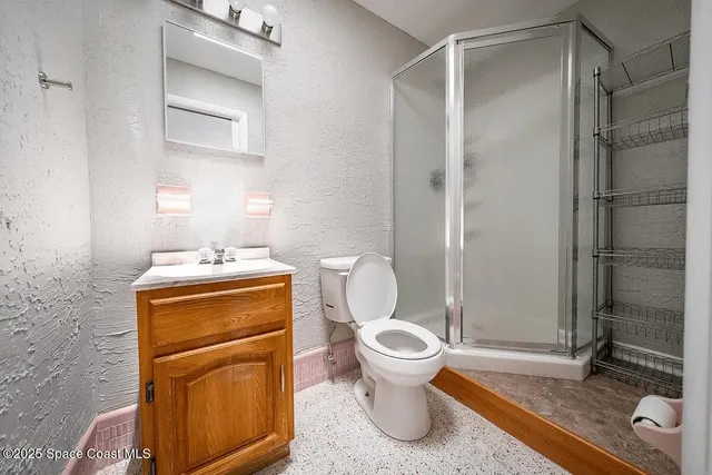 a bathroom with a granite countertop sink toilet a mirror and shower