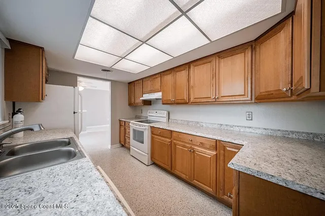 a kitchen with a sink a refrigerator and cabinets