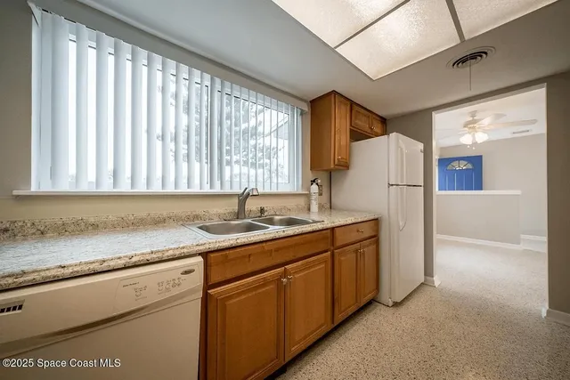 a kitchen with granite countertop cabinets stainless steel appliances and a sink