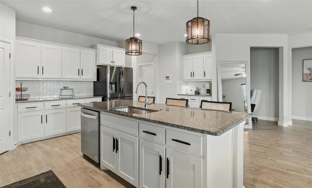 712 Finchley Drive Fort Worth, TX 76247 - Photo 6 of 37 a kitchen with stainless steel appliances granite countertop a sink and dishwasher with white cabinets