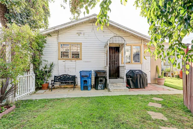 a view of a house with backyard and a tree