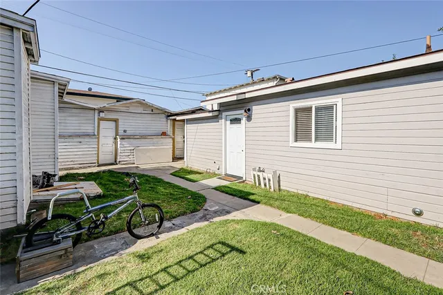 a backyard of a house with potted plants and large tree