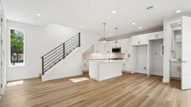a open kitchen with white cabinets and stainless steel appliances