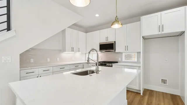 a kitchen with stainless steel appliances granite countertop a sink a stove and cabinets