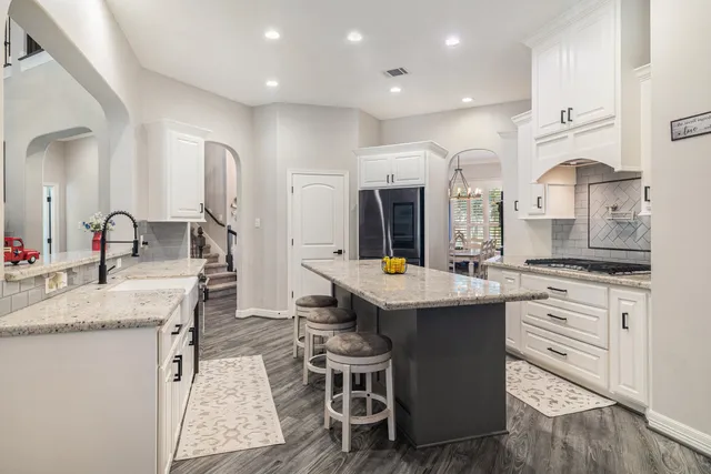 a kitchen with stainless steel appliances granite countertop a sink stove and refrigerator