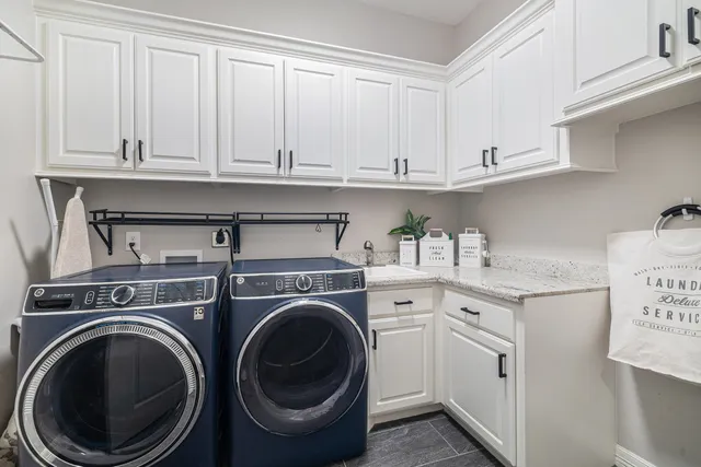 a utility room with sink dryer and washer