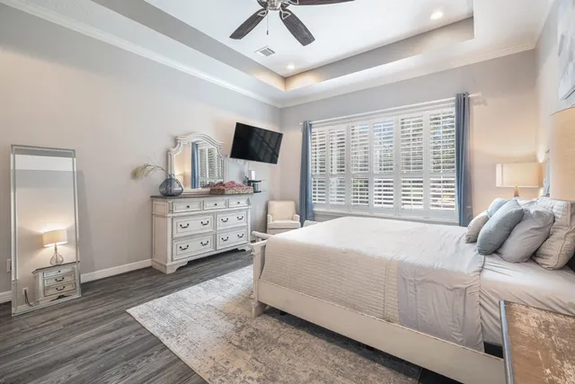 a bedroom with a bed a couch and a chandelier