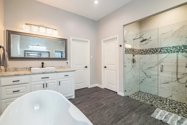 a bathroom with a granite countertop sink mirror and shower