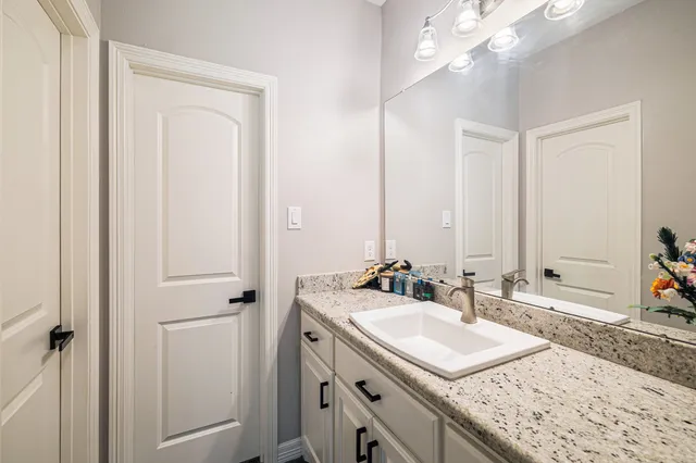 a bathroom with a sink vanity granite and a mirror