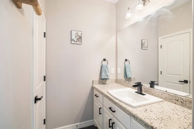 a bathroom with a granite countertop sink and a mirror