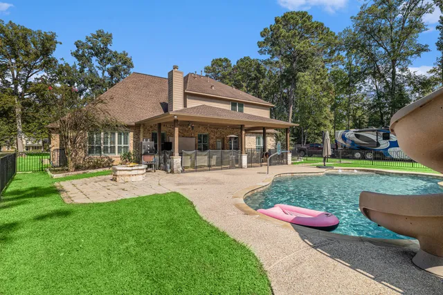 a view of a patio with table and chairs potted plants and large tree