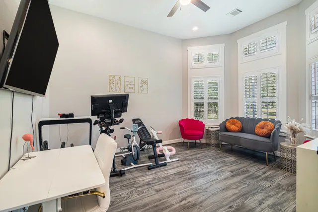 a bedroom with furniture a flat screen tv and a window