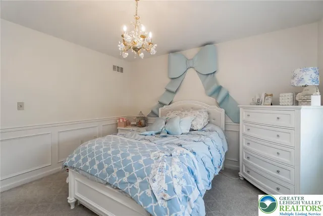 a view of a bedroom with a bed and wooden floor