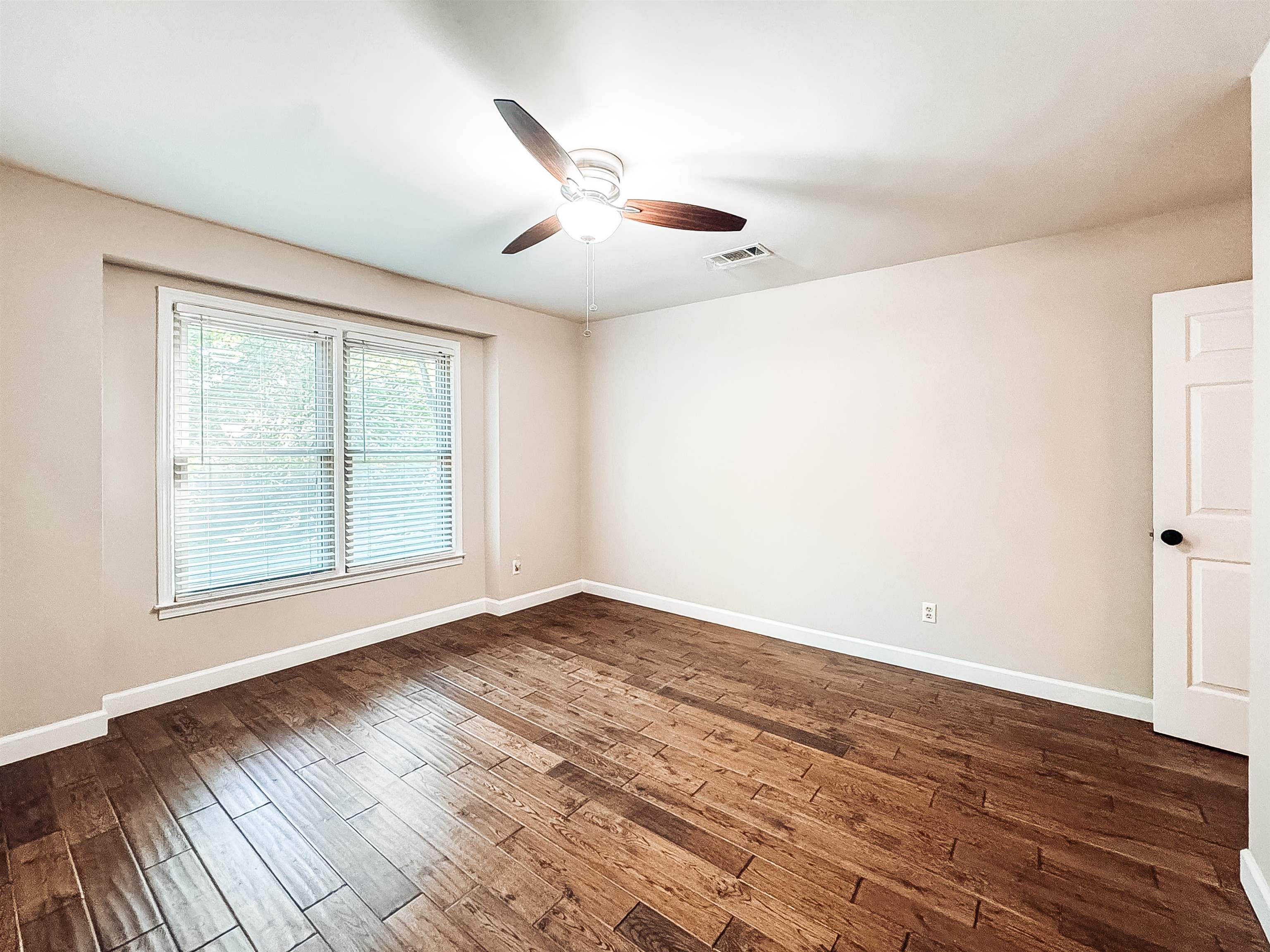 832 South Tree Drive Collierville, TN 38017 - Photo 26 of 40 Room featuring wood-finish flooring, a ceiling fan with integrated lighting, a large window with blinds, and white trim throughout