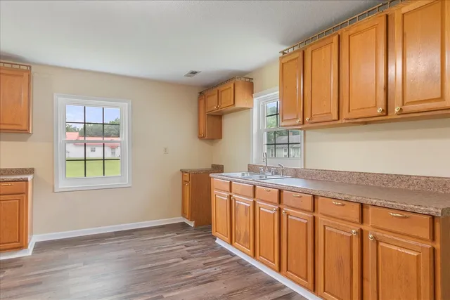 a kitchen with stainless steel appliances granite countertop wooden cabinets a sink and a window