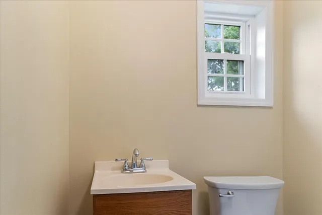 a bathroom with a sink a toilet and a window