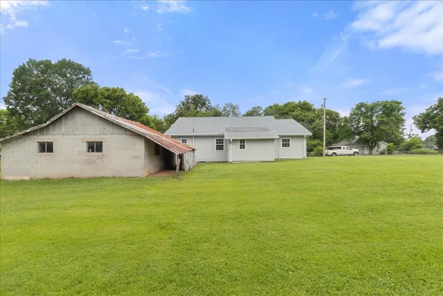 a white house sitting in middle of a field