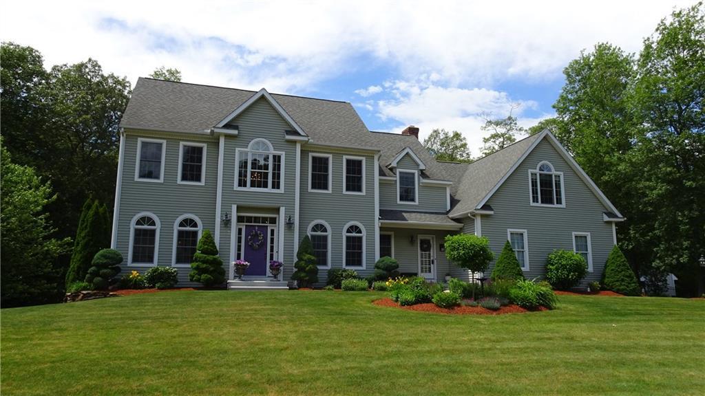 a front view of a house with a yard and trees