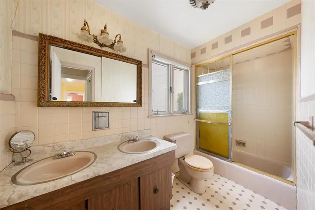 a bathroom with a granite countertop sink toilet and mirror