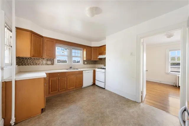 a large kitchen with granite countertop a stove a sink dishwasher and a refrigerator