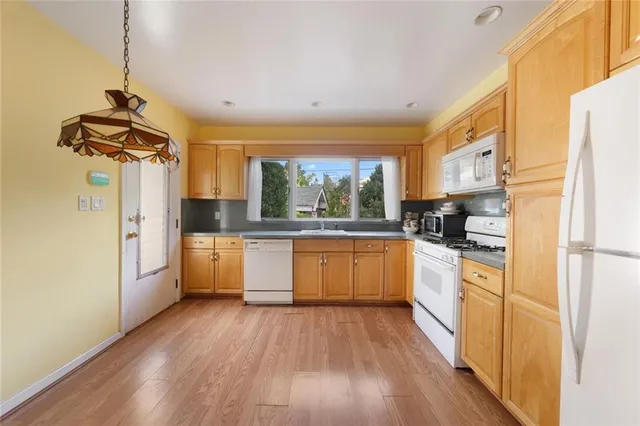 a kitchen with a refrigerator a stove top oven a counter space and wooden floor