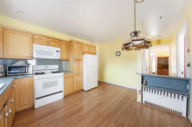 a kitchen with a refrigerator a stove top oven and a window