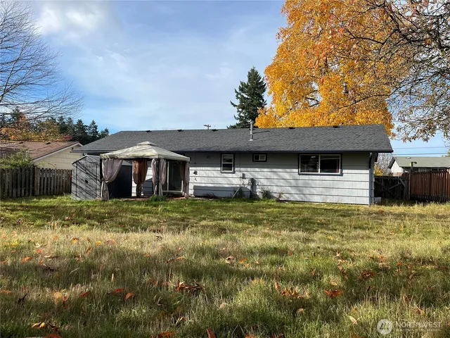 a backyard of a house with table and chairs