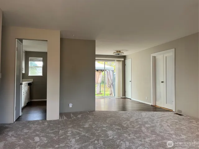 an empty room with windows and a view of bathroom