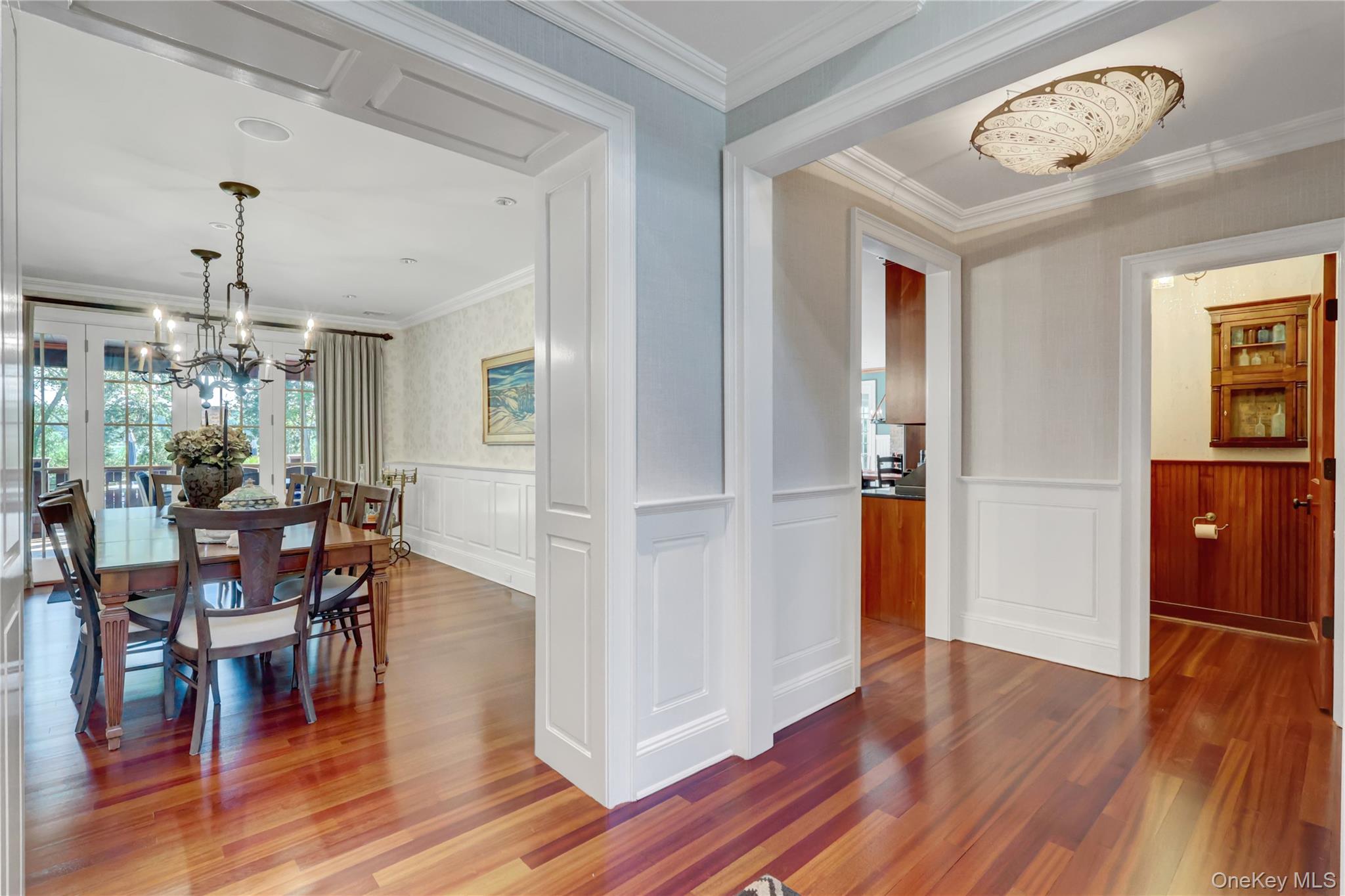 63 Dyke Road Setauket, NY 11733 - Photo 8 of 49 Dining area with a chandelier, crown molding, wood finished floors, and a wainscoted wall