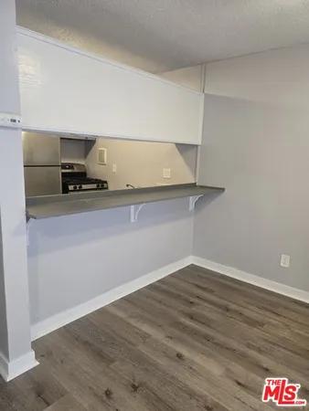 a room with a wooden floor and cabinets