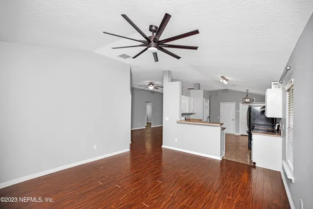 a view of a kitchen with wooden floor and a ceiling fan