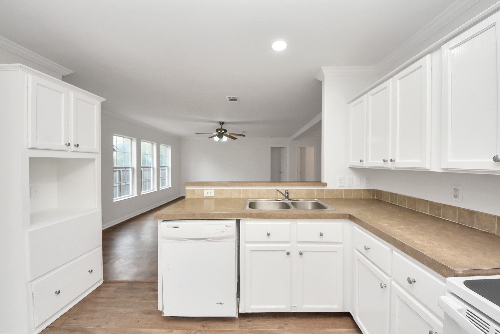 6526 Carver Road, Unit A Houston, TX 77091 - Photo 13 of 31 a kitchen with a sink dishwasher and white cabinets with wooden floor
