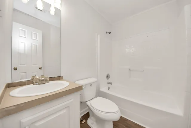 a bathroom with a sink toilet vanity and shower