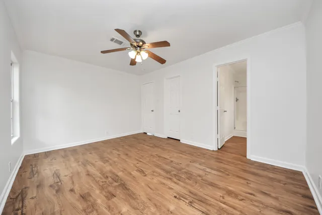 a view of empty room with wooden floor
