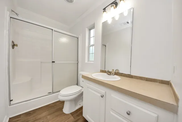 a bathroom with a sink a toilet and shower