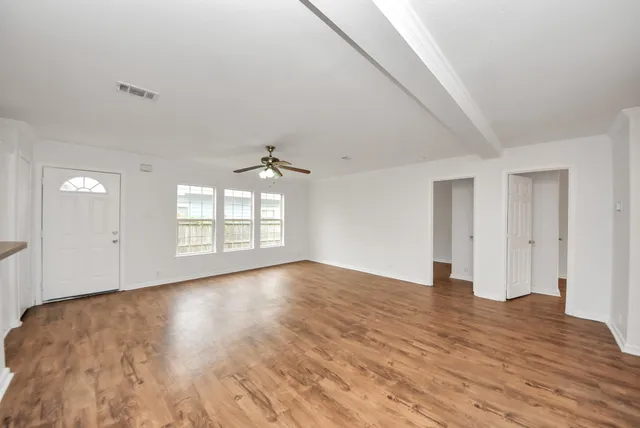 wooden floor in an empty room with a window