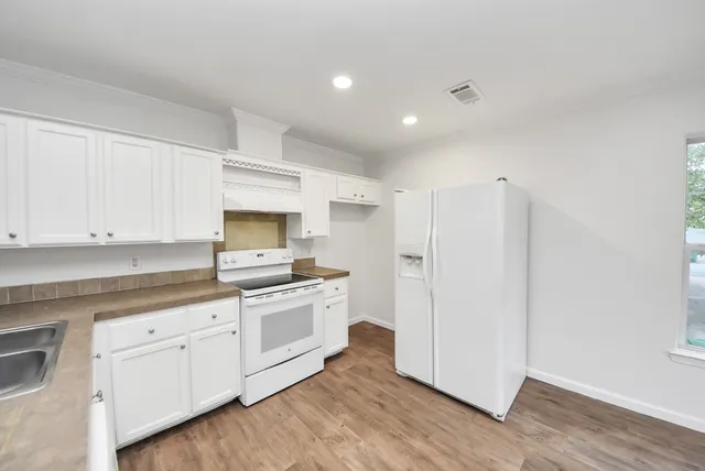 a kitchen with white cabinets and stainless steel appliances