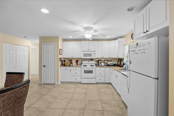 a kitchen with white cabinets and white appliances