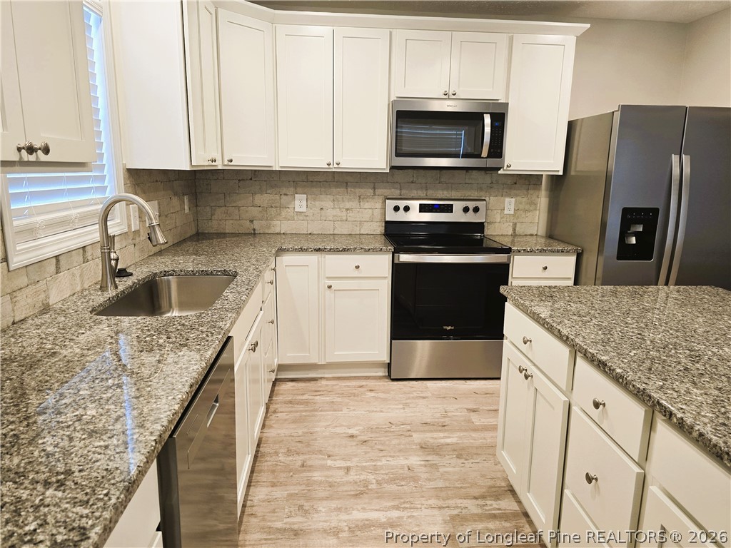 422 Mitchell Farm Road Goldsboro, NC 27530 - Photo 21 of 28 a kitchen with stainless steel appliances granite countertop a sink stove microwave and refrigerator